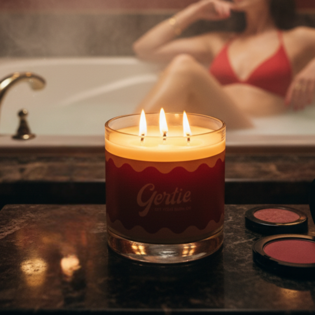 Red candle labeled 'Gertie' with a blurred background of a person in a bathtub.