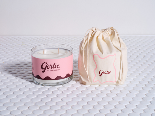 Gertie Palma Rosa 450g Candle and drawstring bag on a textured surface