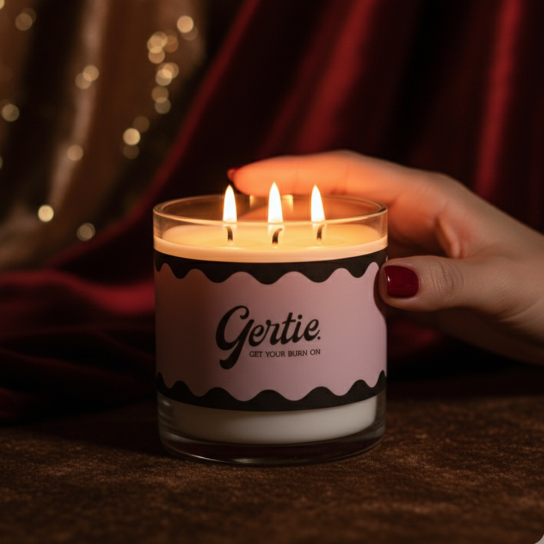 Candle with 'Gertie' label held by a hand against a dark background