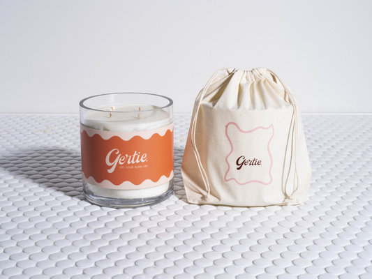 Gertie Sunny Peach 2kg Candle and drawstring bag on a textured surface
