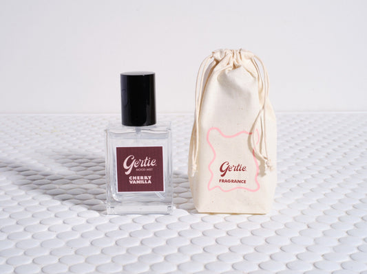 A bottle of 'Jungle Room Mist' fragrance with a label and a reusable cotton pouch, both featuring a brand logo.